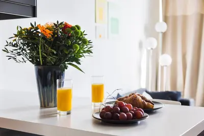 a table with a plate of food and two glasses of orange juice at Brussels St Gilles Elegant residence in Brussels