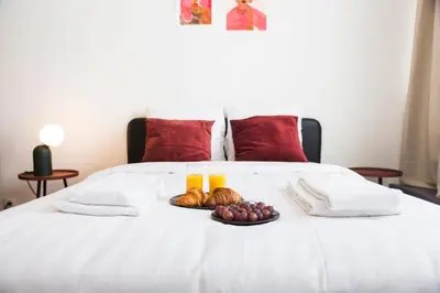 a tray of fruit on a bed with two candles at Brussels St Gilles Elegant residence in Brussels