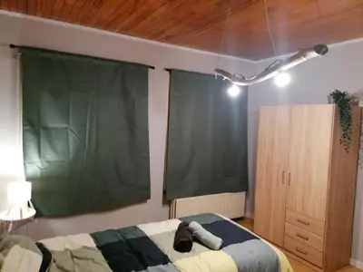 a bedroom with a bed and a green curtain at Rent and Relax Geel in Geel