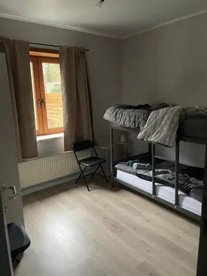 a bedroom with two bunk beds and a chair at Rent and Relax Geel in Geel