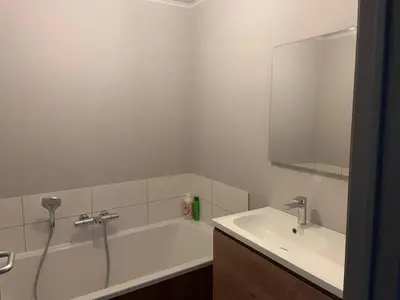 a bathroom with a tub and a sink and a mirror at Rent and Relax Geel in Geel