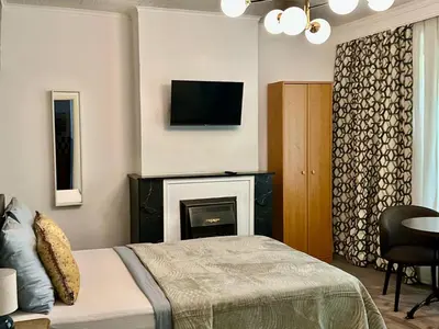 a bedroom with a fireplace and a tv on the wall at Happy Home in Brussels
