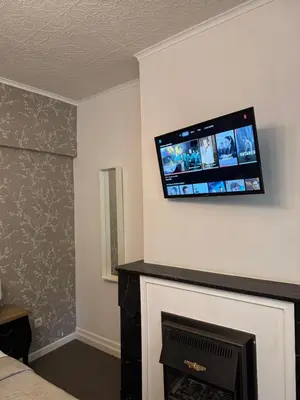 a room with a fireplace with a flat screen tv on the wall at Happy Home in Brussels