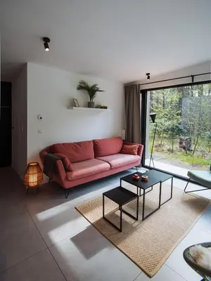 a living room with a red couch and a table at Knuscabin in Lille