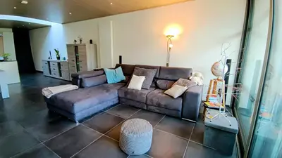 a living room with a couch and a table at Rustig gelegen woning in Tielrode in Temse