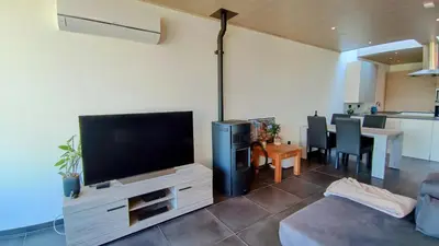 a living room with a flat screen tv on a entertainment center at Rustig gelegen woning in Tielrode in Temse