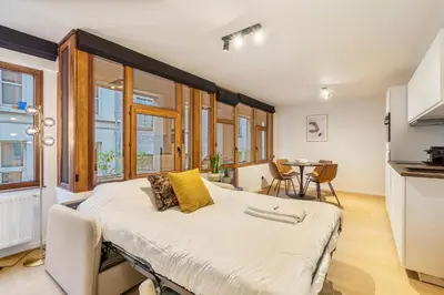 a bedroom with a large bed and a table at Gezellig & Centraal - 4 Persoons Gentse Studio in Ghent