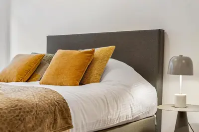 a bed with yellow pillows on top of it at Charmante Studio op Toplocatie - Hartje Gent in Ghent