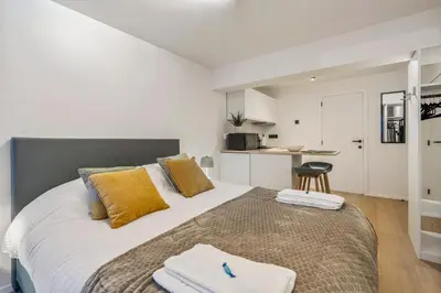 a bedroom with a large bed with yellow pillows at Charmante Studio op Toplocatie - Hartje Gent in Ghent