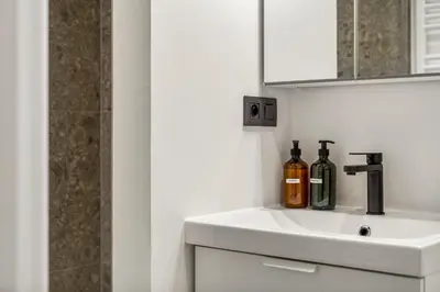 a bathroom with a sink with two bottles on it at Charmante Studio op Toplocatie - Hartje Gent in Ghent