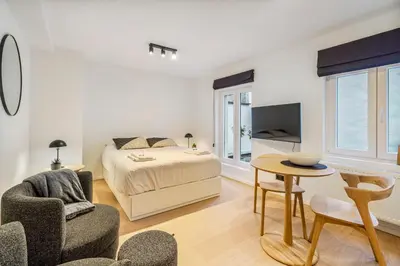 a bedroom with a bed and a table and a chair at Gezellige Gentse Studio - Perfect Voor Koppels in Ghent