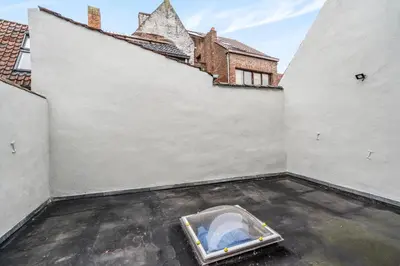 an empty room with a bed in the middle of a building at Gezellige Gentse Studio - Perfect Voor Koppels in Ghent