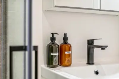 two bottles sitting on top of a bathroom sink at Gezellige Gentse Studio - Perfect Voor Koppels in Ghent