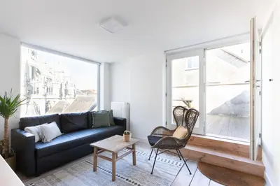 a living room with a couch and a large window at Charming duplex apartment with spectacular views in Antwerp
