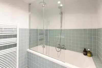 a bathroom with a tub and a glass shower at Charming duplex apartment with spectacular views in Antwerp