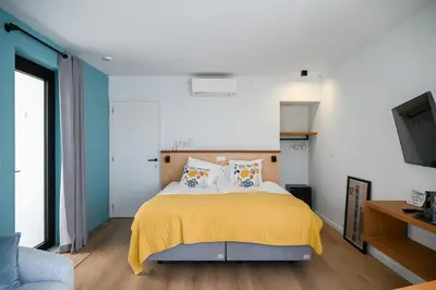 a bedroom with a bed with a yellow blanket at het Boekenhof in Niel