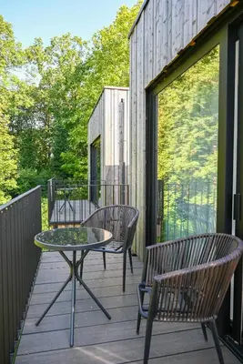 a patio with a table and chairs on a deck at het Boekenhof in Niel
