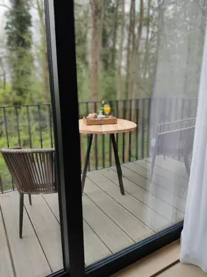 a table and a chair on a screened in porch at het Boekenhof in Niel