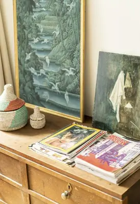 a wooden dresser with books and a painting on it at Cozy Room with Garden in Brussels