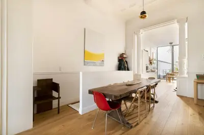 a dining room with a wooden table and red chairs at Cozy Room with Garden in Brussels