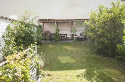 a garden with a table in the back of a house at Cozy Room with Garden in Brussels