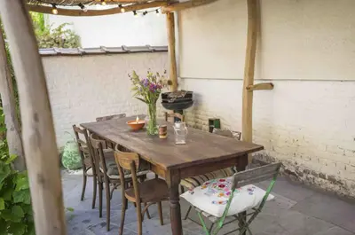 a wooden table and chairs on a patio at Cozy Room with Garden in Brussels