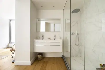 a white bathroom with a sink and a shower at Cozy Room with Garden in Brussels