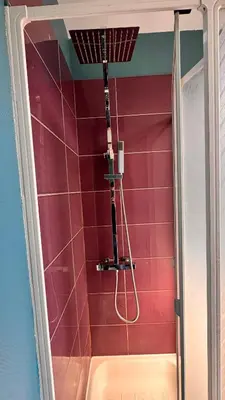 a bathroom with a shower with pink tiles at T2 Neuf Quartier Calme central et transport devant in Brussels