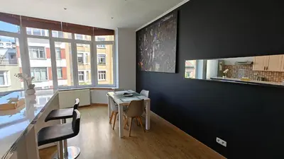 a dining room with a table and chairs and a window at Suite Diamant - Chic & Lumineux in Brussels