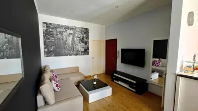 a living room with a couch and a tv at Suite Diamant - Chic & Lumineux in Brussels