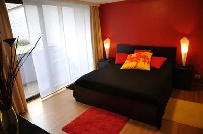 a bedroom with a black bed with red and yellow pillows at Apartment Home Frit Home in Brussels