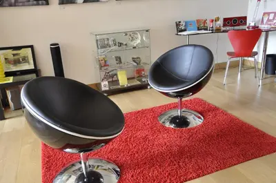 two black chairs sitting on top of a red rug at Apartment Home Frit Home in Brussels