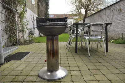 a grill on a patio with chairs and a table at Apartment Home Frit Home in Brussels