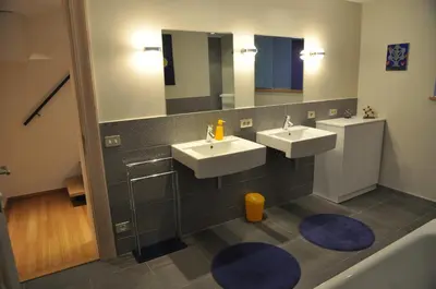 a bathroom with two sinks and two mirrors at Apartment Home Frit Home in Brussels