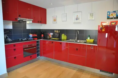 a kitchen with red cabinets and a sink at Apartment Home Frit Home in Brussels