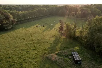 an aerial view of a large field with a boat in it at Gorgeous Off-Grid Tiny House Near Antwerp, Belgium in Wuustwezel