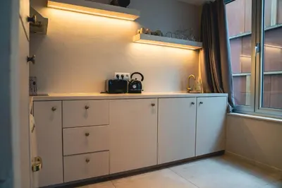 a kitchen with white cabinets and a window at Japandi Lofts - 2 Bedrooms at old city of Antwerp in Antwerp
