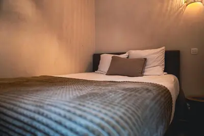 a bed with a pillow on it in a room at Japandi Lofts - 2 Bedrooms at old city of Antwerp in Antwerp