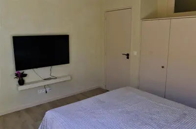 a bedroom with a bed and a flat screen tv at Japandi Lofts - 2 Bedrooms at old city of Antwerp in Antwerp