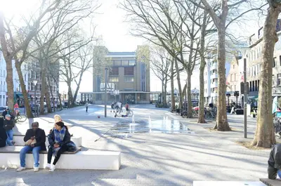two people sitting on a bench on a city street at Japandi Lofts - 2 Bedrooms at old city of Antwerp in Antwerp