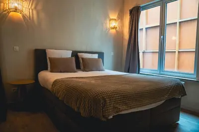a bedroom with a large bed with a window at Japandi Lofts - 2 Bedrooms at old city of Antwerp in Antwerp