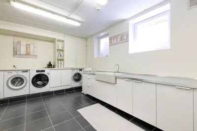 a white laundry room with washing machines and a sink at The Haven in Sint-Genesius-Rode