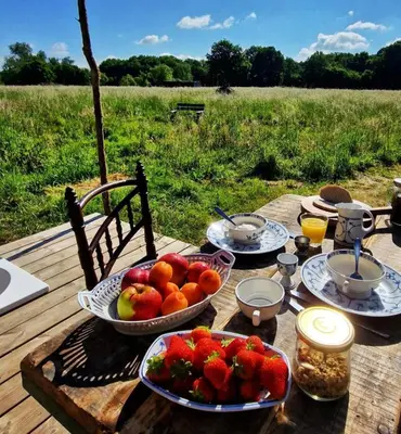 a wooden table with plates of fruit on it at Strackxhoeve Yurt 'Haardpeer' in Laakdal