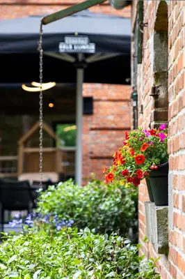 a street sign hanging from a brick building with flowers at Comfortabele groepswoning voor 8 met ruimte tuin in Turnhout