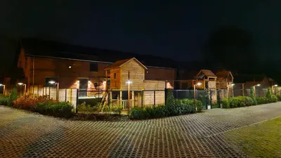 a building with a fence in front of it at night at Comfortabele groepswoning voor 8 met ruimte tuin in Turnhout