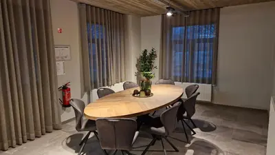 a dining room with a table and chairs and two large windows at Comfortabele groepswoning voor 8 met ruimte tuin in Turnhout
