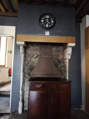 a clock on top of a wall with a fireplace at Dolfijn Hostel in Antwerp