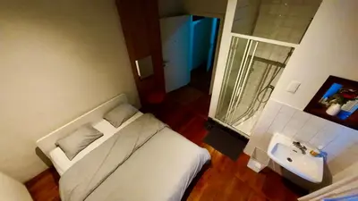 a small bathroom with a bed and a sink at Dolfijn Hostel in Antwerp