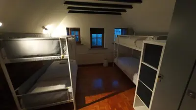 a room with two bunk beds and a hallway with windows at Dolfijn Hostel in Antwerp