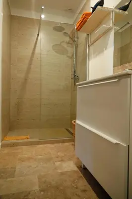 a shower with a glass door in a bathroom at Bakkershuisje Kraneveldhoeve in Haacht